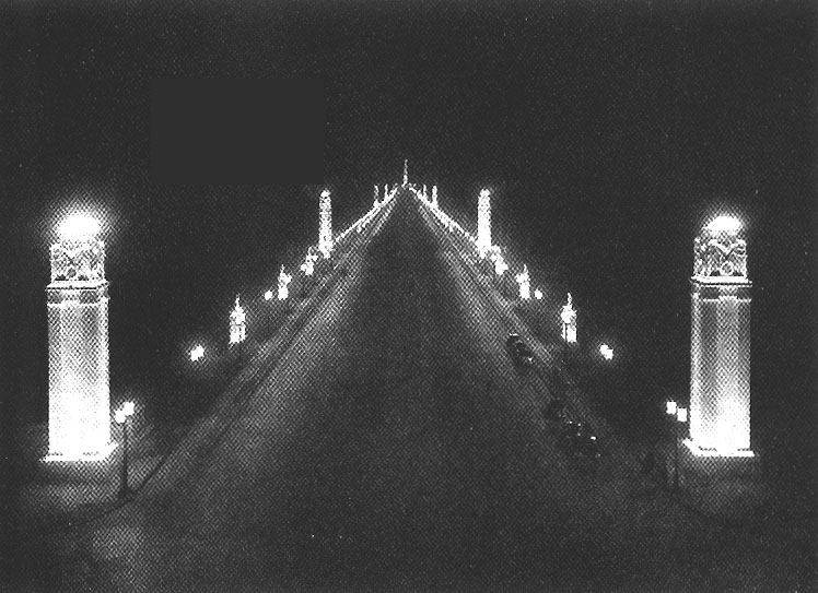 Blick vom Brandenburger Tor, Berlin, auf die Ost-West-Achse. Anleuchtung der Pylonen und der im Hintergrund sichtbaren Siegessule durch KANDEM-Anleuchtgerte (30er Jahre des 20. Jahrhunderts).